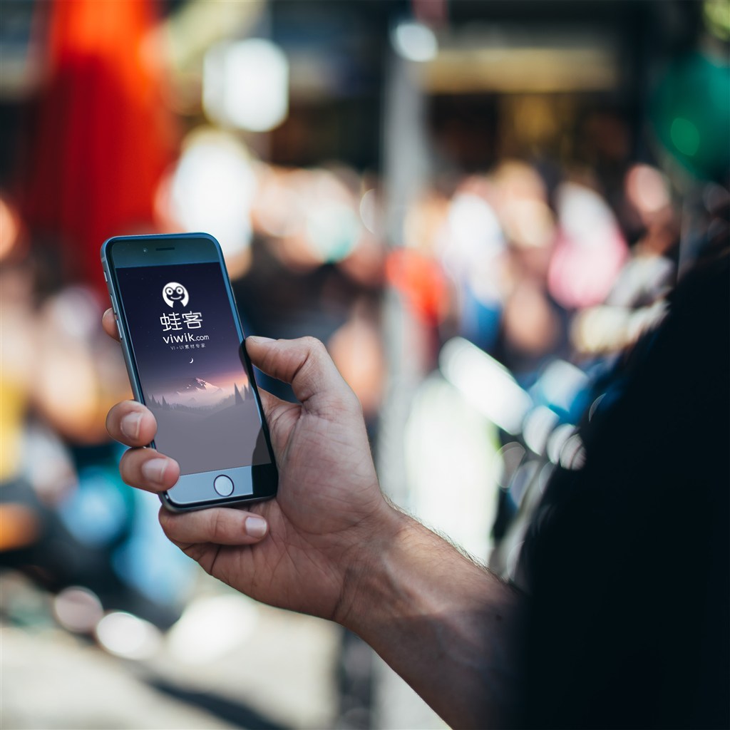 人群中手持iPhone手机样机